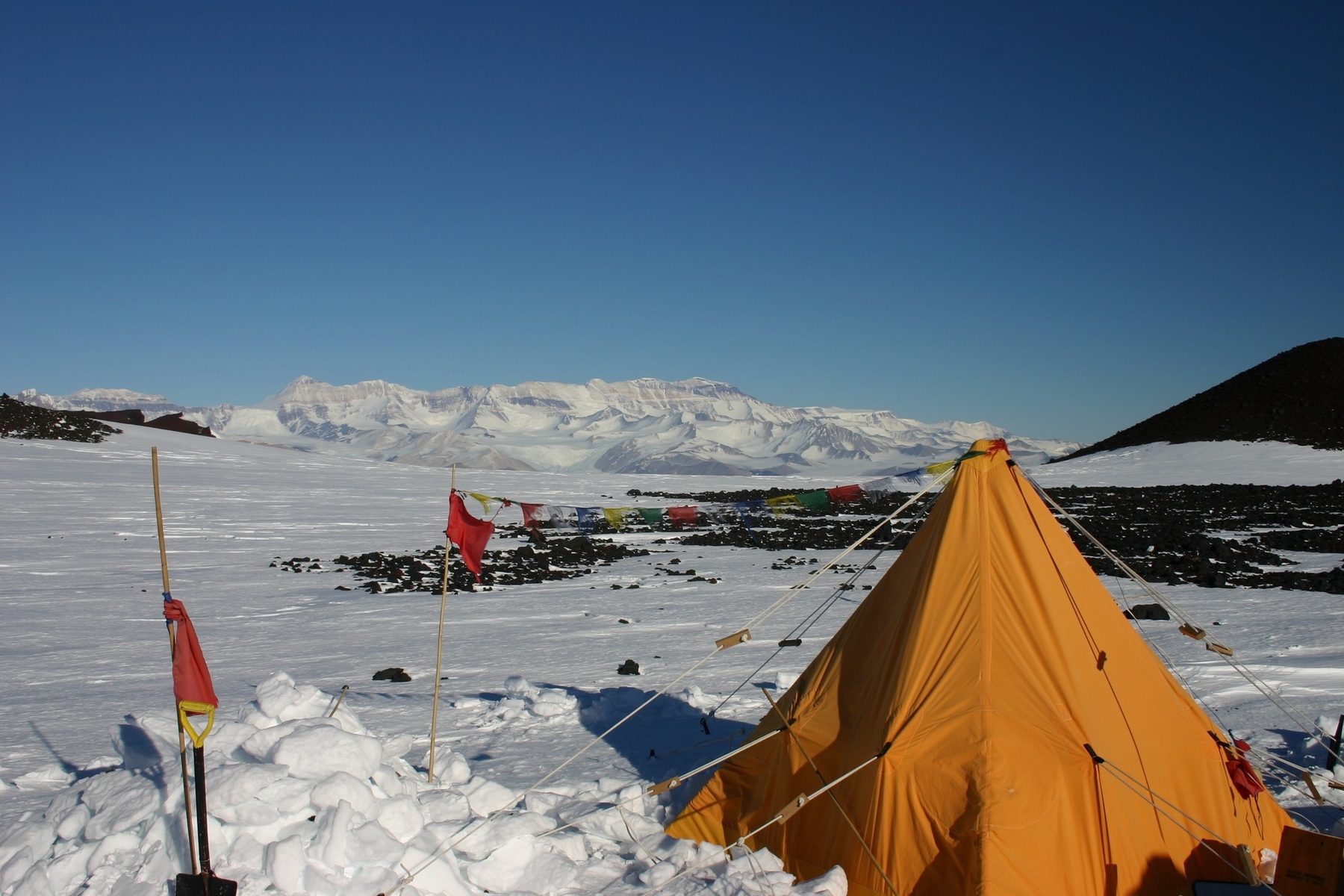 A field camp tent on the ice with the Transantarctic Mountains behind